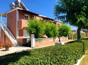 una casa con una recinzione bianca e un albero di Panagiotis Studios a Laganas Altre 30 foto