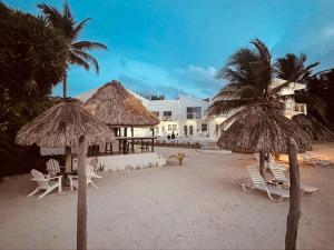 una spiaggia con sedie e ombrelloni e un edificio di Mata Rocks Resort a San Pedro