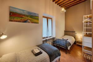 a bedroom with two beds and a painting on the wall at CasaZappa - In centro a piedi, parcheggio e giardino privato in Siena