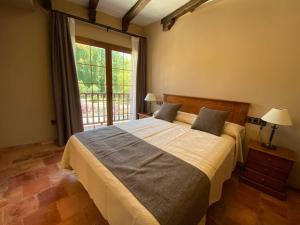 a bedroom with a large bed and a large window at Hotel Rural El Lagar de Nemesio in Perales de Tajuña