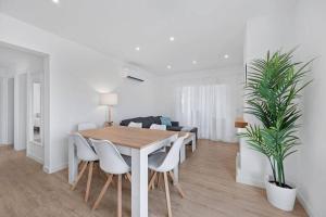 een eetkamer met een houten tafel en stoelen bij Apartamento tranquilo a 500m de la playa in Punta Grossa