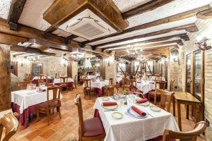 un restaurante con mesas y sillas en una habitación en Hotel Rural El Lagar de Nemesio, en Perales de Tajuña