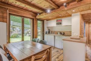 une cuisine avec une grande table en bois dans une maison dans l'établissement Appartement des Cerisiers - Welkeys, à Megève