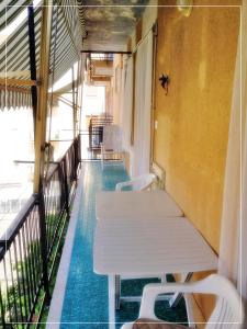 a corridor with white tables and chairs on a balcony at La casa di Palma in Alassio