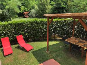 three chairs and a table in a yard with a woodenilion at CasaZappa - In centro a piedi, parcheggio e giardino privato in Siena