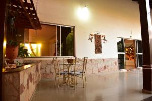 a bar with chairs and a table in a room at Ecos Hotel Tourist in Rolim de Moura