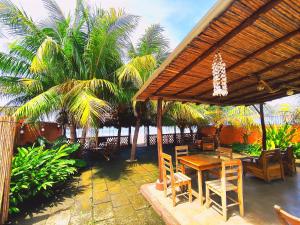 拉斯佩尼塔斯的住宿－El Belga Loco，一个带桌椅和棕榈树的庭院