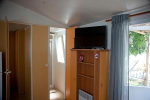 um quarto com uma televisão numa cómoda com uma janela em Cortijo Flamingos em Chiclana de la Frontera