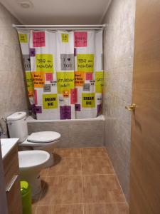 a bathroom with a toilet and posters on the wall at Fuerte Heaven in Costa de Antigua