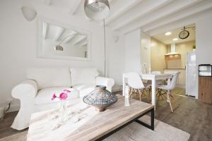 a living room with a white couch and a table at The White Flats Sant Antoni in Barcelona