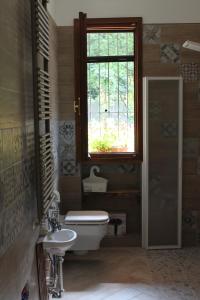 a bathroom with a toilet and a sink and a window at Nel giardino di Dafne in Stresa