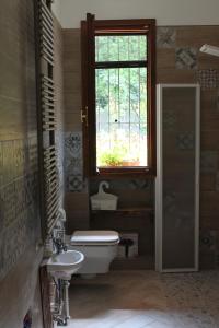 baño con aseo y lavabo y ventana en Nel giardino di Dafne, en Stresa