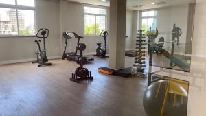 a gym with several treadmills and machines in a room at Casa da Dinda in Ilhéus