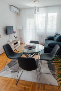 salon ze stołem, krzesłami i kanapą w obiekcie Suite Dreams w mieście Valjevo