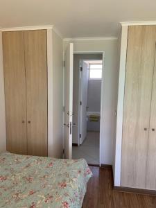 1 dormitorio con 1 cama y puerta que da a un pasillo en Departamentos Laguna del mar, en La Serena