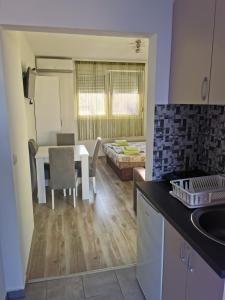 a kitchen and living room with a table and a dining room at Apartmani Manila, Terme-popust, Akva park-popust in Vrnjačka Banja