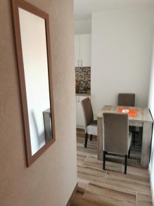 a dining room with a table and chairs and a mirror at Apartmani Manila, Terme-popust, Akva park-popust in Vrnjačka Banja