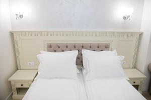 - 2 lits avec des oreillers blancs dans une chambre dans l'établissement Imperial Hotel&Spa - Baile Olanesti, à Băile Olăneşti