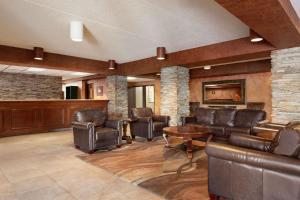 a living room with leather furniture and a fireplace at Ramada by Wyndham Fargo in Fargo