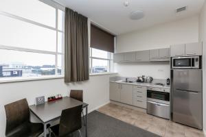 a kitchen with a table and a dining room at Quest New Plymouth Serviced Apartments in New Plymouth