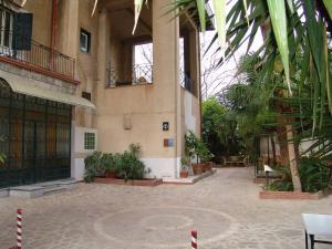 a large building with a courtyard with plants at Hotel Villa Archirafi in Palermo