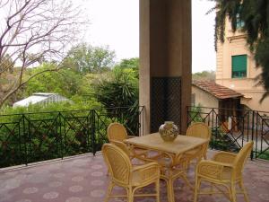 a table and chairs on a patio with a balcony at Hotel Villa Archirafi in Palermo