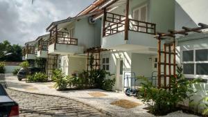 a white building with balconies and a street at Casa com piscina e churrasq na Praia de Camburí in São Sebastião