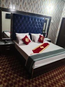 a bed with red pillows on it in a room at Royal palace hotel in Lahore