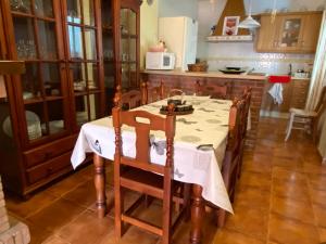 uma cozinha com uma mesa com uma toalha de mesa branca em Casa Abuelo Juan - Benaocaz- 2 dormitorios em Benaocaz