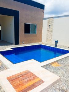 una piscina de agua azul frente a una casa en Casa Marilago en Camocim