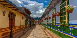 an alley with colorful buildings and potted plants at Hotel El Paisaje in Guatapé