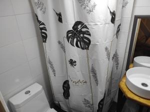 CENTRAL LOFT في إكيكي: حمام مع ستارة دش فراشة بجانب المرحاض