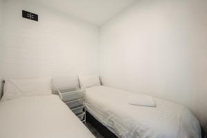 two beds in a small room with white walls at Snow Ski Apartments 20 in Falls Creek