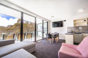 a living room with a couch and a table with chairs at Snow Ski Apartments 20 in Falls Creek