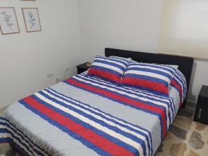 een bed met een blauw en rood gestreepte deken bij Laureles 301 in Medellín