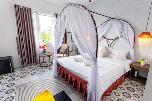 ein Schlafzimmer mit einem Himmelbett in der Unterkunft The Dreamers Homestay in Hue