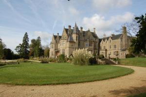 ein altes Schloss mit einem Rasenplatz davor in der Unterkunft Orchardleigh Estate in Frome