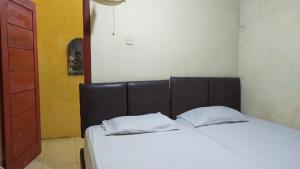 a bedroom with a bed with two pillows on it at Aqsa Guest House Banjarsari in Banjarsari +13 photos