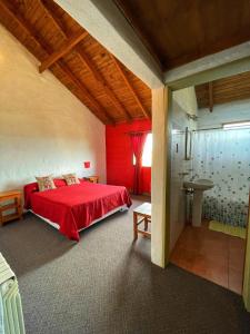 a bedroom with a red bed and a bathroom at Bla Lodge in El Calafate