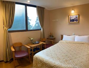 a hotel room with a bed and a window at 登山別館 in Zhongzheng