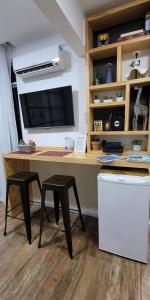 a desk with two stools and a computer monitor at Apezinho.Loft in Rio de Janeiro