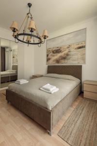 ein Schlafzimmer mit einem großen Bett und einem Kronleuchter in der Unterkunft BOROVOE Country Club in Borovoye