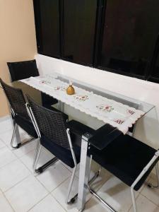 - une table à manger avec des chaises, une table et des chaises dans l'établissement Apt Jatiúca, Excelente Localização.balada, Praia.., à Maceió