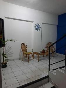 - un salon avec deux chaises et une table dans l'établissement Apt Jatiúca, Excelente Localização.balada, Praia.., à Maceió