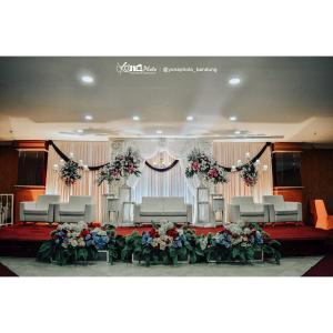 a room with chairs and a stage with flowers at PIA Hotel Bandung in Bandung