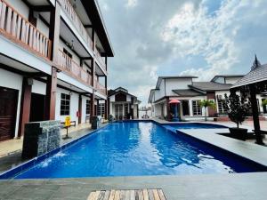 a large blue swimming pool next to a building at Dz Residence Tunjong in Kota Bharu