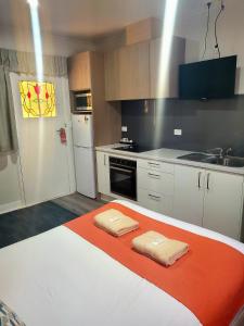 a kitchen with a bed with two towels on it at Sturt Motel in Broken Hill