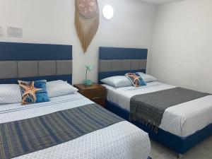 ein Schlafzimmer mit zwei Betten mit blau-weißer Bettwäsche in der Unterkunft blue angel 4 in Playa del Carmen + 46 Fotos