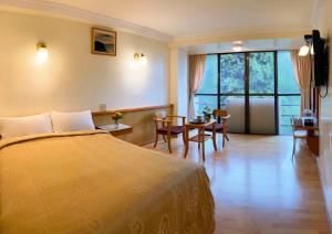 una camera d'albergo con letto, tavolo e sedie di 登山別館 a Zhongzheng