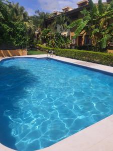 una piscina de agua azul frente a una casa en La Casita de Naomi en Tamarindo